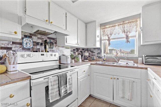 kitchen with tile countertops, white range with electric cooktop, white cabinets, sink, and decorative backsplash