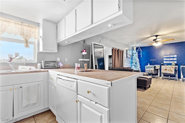 kitchen featuring dishwasher, kitchen peninsula, and white cabinets