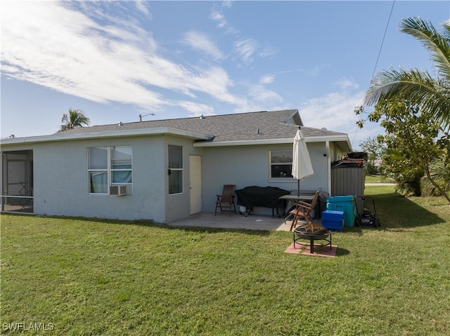 back of property featuring a patio, a fire pit, and a lawn