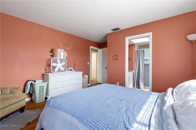 bedroom featuring hardwood / wood-style floors and ensuite bath