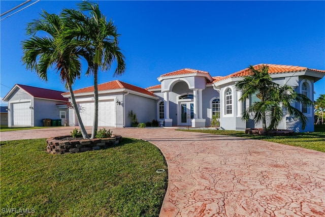 mediterranean / spanish-style home with a front yard and a garage