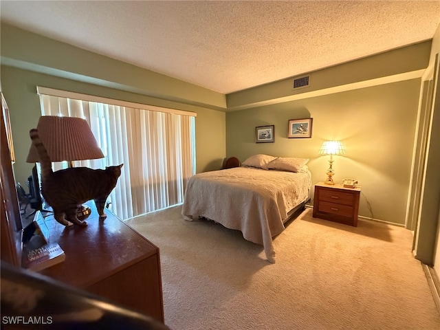 bedroom featuring light carpet and a textured ceiling