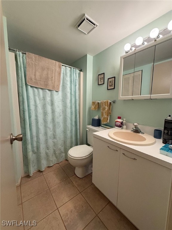 bathroom featuring vanity, tile patterned floors, and toilet