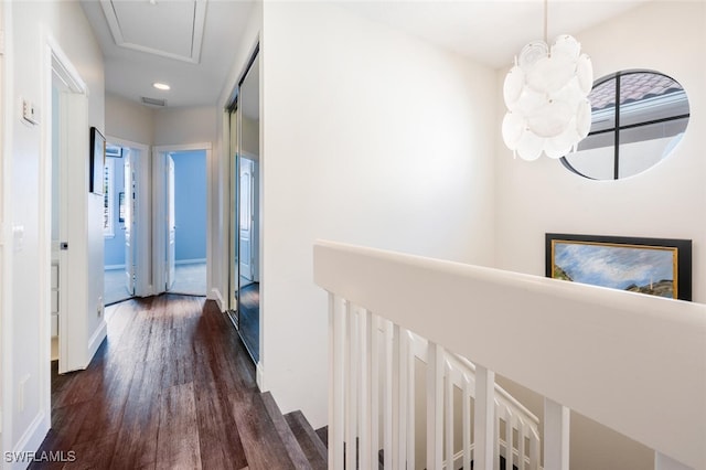 hallway featuring an inviting chandelier and dark wood-type flooring