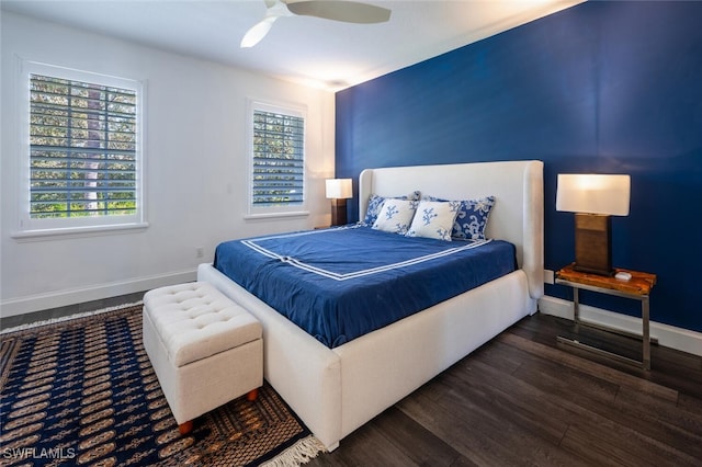 bedroom with ceiling fan, dark wood-type flooring, and multiple windows