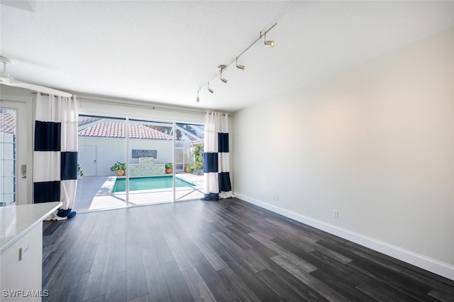 interior space with a wealth of natural light, dark wood-type flooring, and a textured ceiling