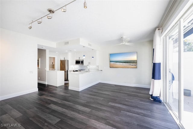 unfurnished living room with dark hardwood / wood-style flooring, ceiling fan, and sink