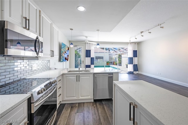 kitchen with decorative backsplash, stainless steel appliances, sink, decorative light fixtures, and white cabinetry