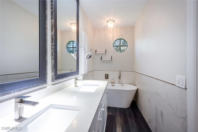 bathroom with a bath, hardwood / wood-style floors, and vanity