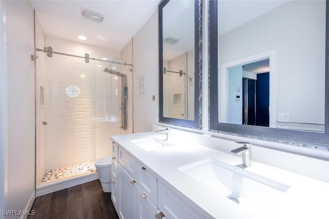 bathroom featuring hardwood / wood-style flooring, vanity, toilet, and walk in shower