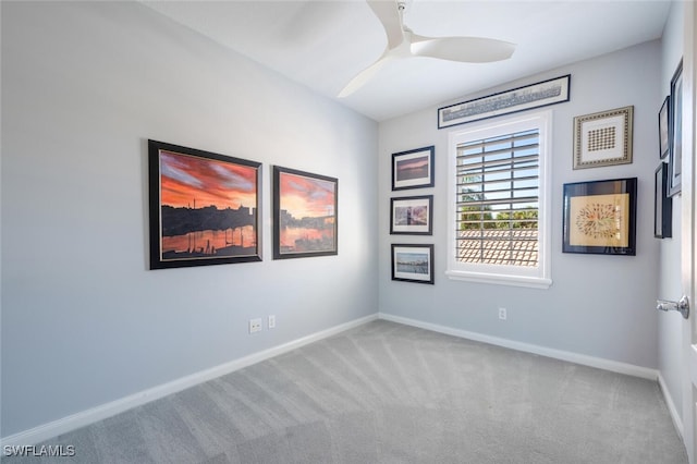 spare room with light colored carpet and ceiling fan