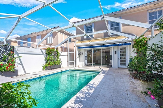 view of pool featuring glass enclosure and a patio area