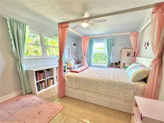 tiled bedroom with ceiling fan and a textured ceiling