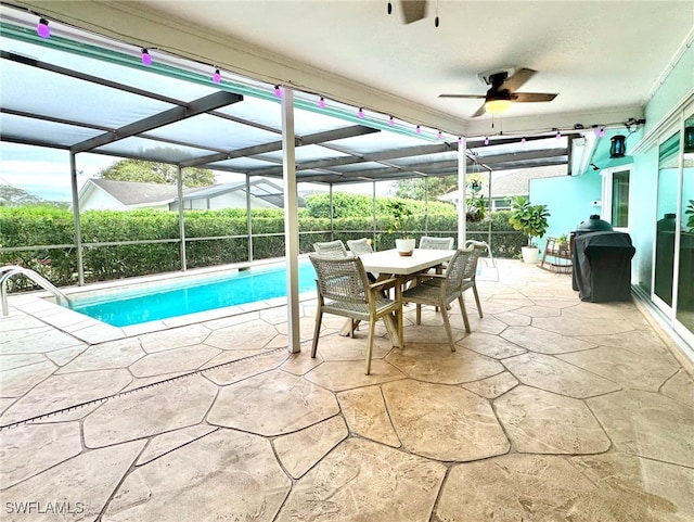 view of pool with a patio, ceiling fan, and glass enclosure