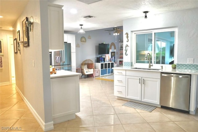 kitchen featuring light tile patterned flooring, appliances with stainless steel finishes, white cabinetry, and sink