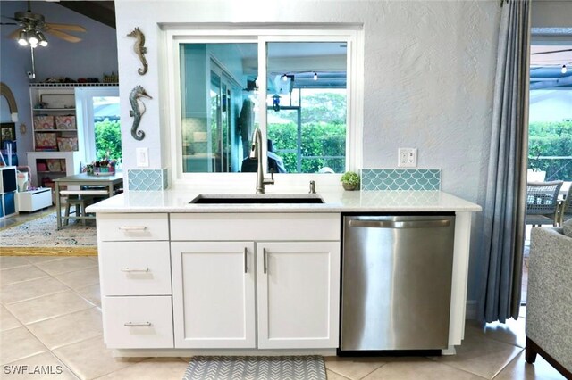 kitchen featuring white cabinetry, sink, stainless steel dishwasher, ceiling fan, and light tile patterned floors