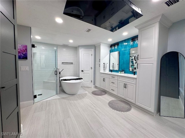 bathroom with hardwood / wood-style floors, separate shower and tub, and vanity