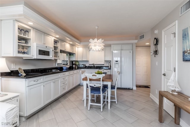 kitchen with white appliances, sink, an inviting chandelier, white cabinetry, and hanging light fixtures