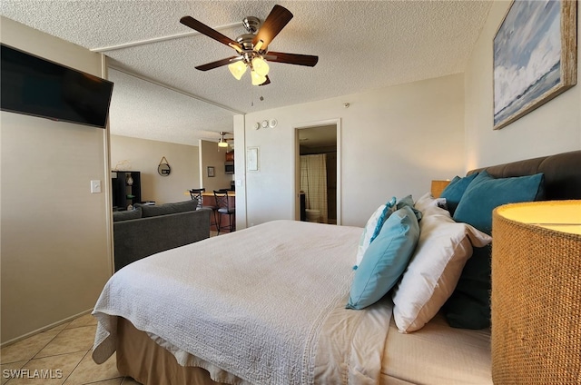 bedroom with ceiling fan, light tile patterned flooring, and a textured ceiling