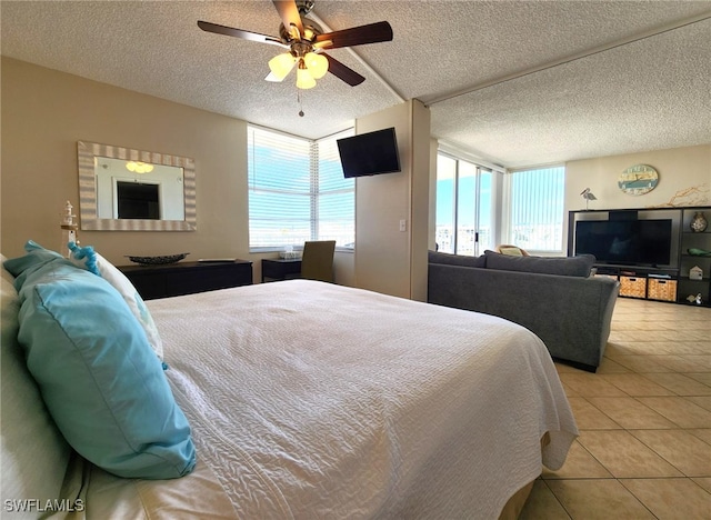 tiled bedroom with ceiling fan and a textured ceiling