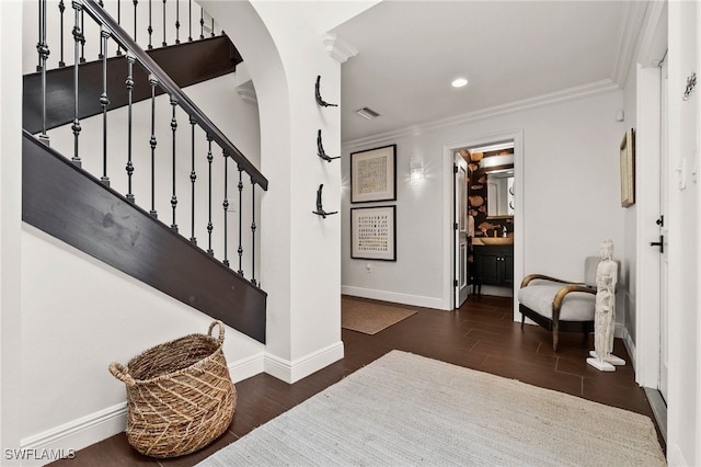 entryway with dark hardwood / wood-style flooring and crown molding