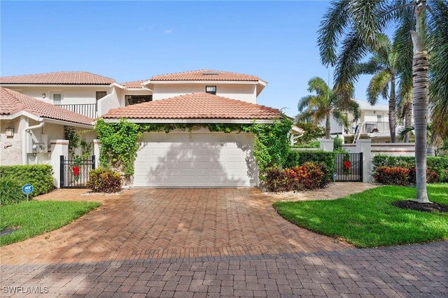 5908 Via Lugano, Naples, FL 34108 - mediterranean / spanish home featuring a gate, an attached garage, fence, driveway, and a tile roof