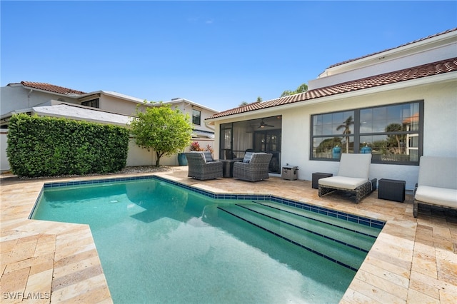 view of swimming pool featuring a sunroom and a patio area