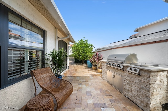 view of patio featuring exterior kitchen and a grill