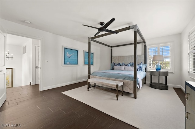 bedroom with ceiling fan with notable chandelier and dark hardwood / wood-style floors