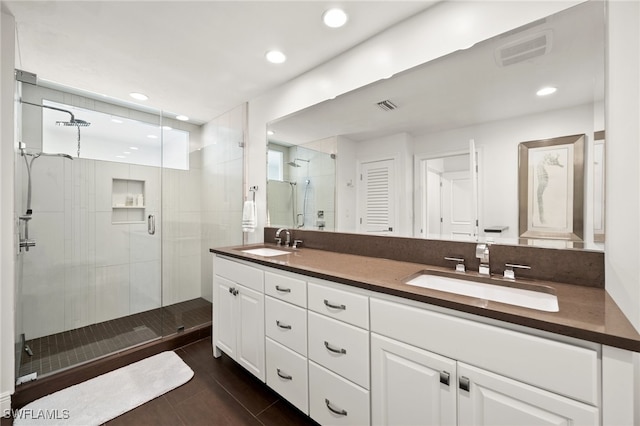 bathroom featuring a shower with door and vanity