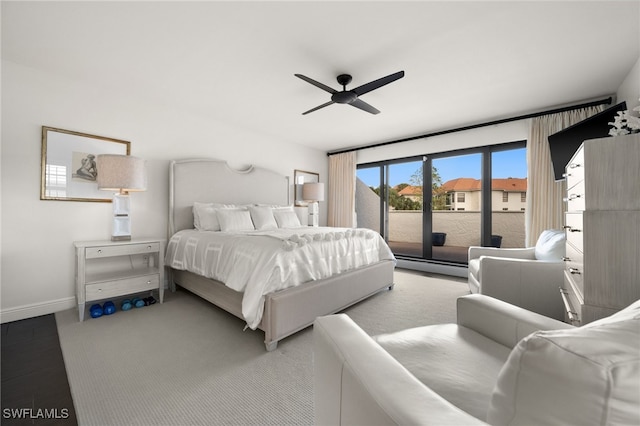 carpeted bedroom with ceiling fan, access to outside, and a baseboard heating unit