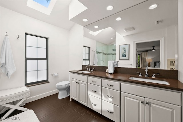 bathroom featuring vanity, ceiling fan, hardwood / wood-style flooring, toilet, and a shower with shower door