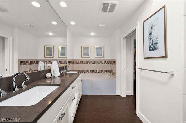 bathroom featuring tiled bath and vanity