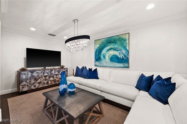 living room with dark hardwood / wood-style flooring, an inviting chandelier, and crown molding