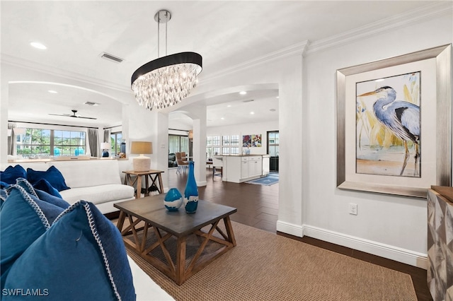 living room featuring ceiling fan with notable chandelier, dark hardwood / wood-style floors, and ornamental molding