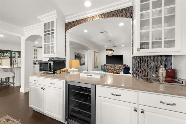 kitchen with wine cooler, white cabinets, dark wood-type flooring, and ornamental molding