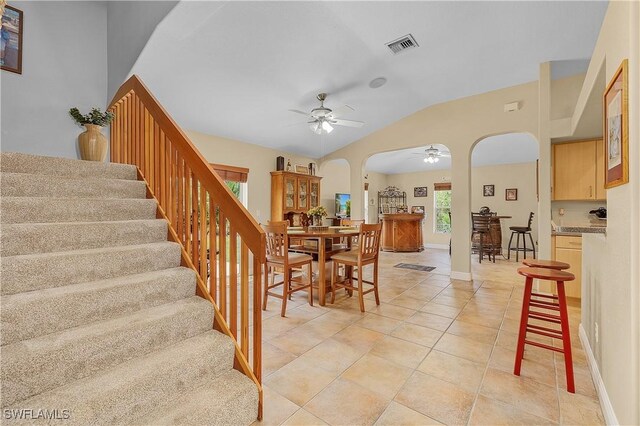 tiled dining room featuring ceiling fan and vaulted ceiling