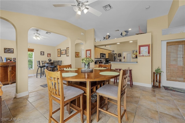 dining area with ceiling fan, light tile patterned floors, and lofted ceiling