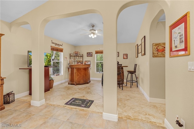 entryway with ceiling fan, lofted ceiling, and indoor bar