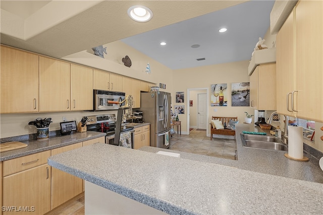 kitchen with sink, light brown cabinets, kitchen peninsula, light tile patterned flooring, and appliances with stainless steel finishes