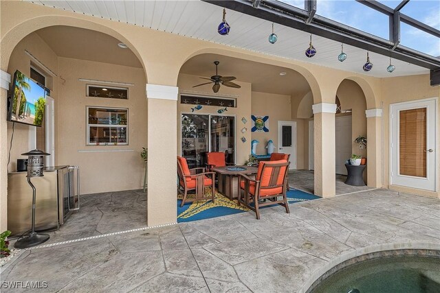 view of pool with glass enclosure, a patio area, and an in ground hot tub