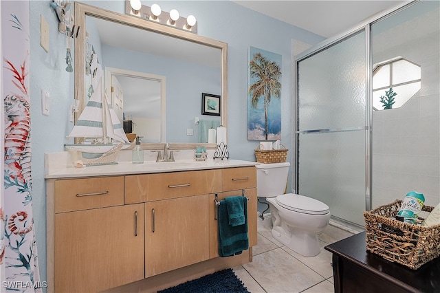 bathroom with tile patterned flooring, vanity, toilet, and a shower with door