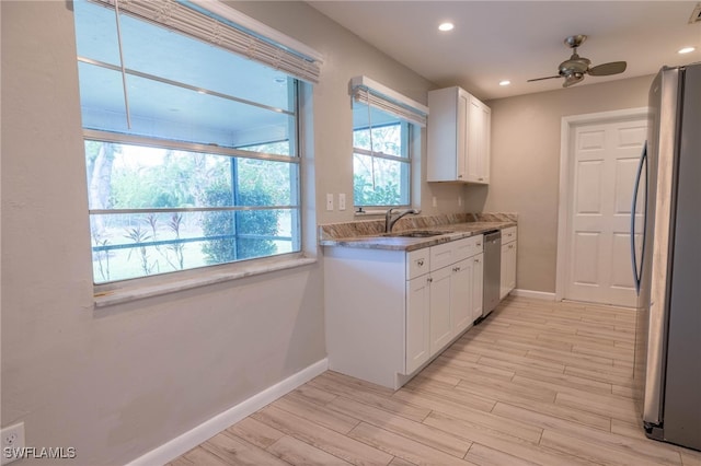 kitchen with white cabinetry, appliances with stainless steel finishes, and light hardwood / wood-style flooring