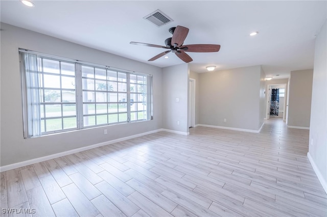 empty room with ceiling fan and light hardwood / wood-style flooring