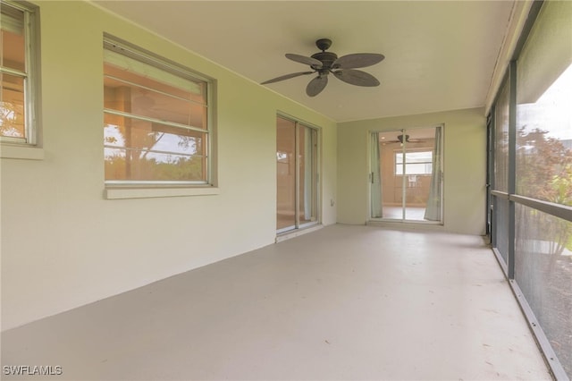 unfurnished sunroom with ceiling fan