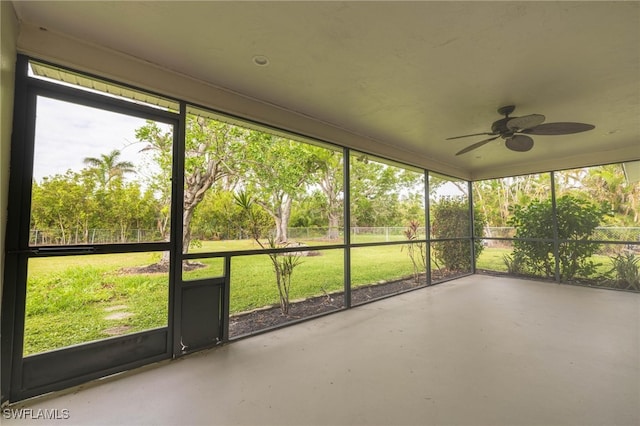 unfurnished sunroom with ceiling fan