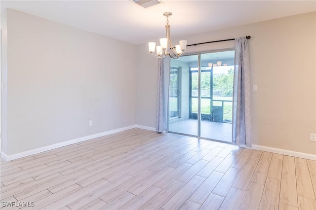 unfurnished room featuring light hardwood / wood-style floors and an inviting chandelier