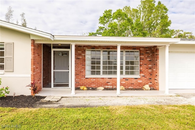 property entrance featuring a lawn and a garage