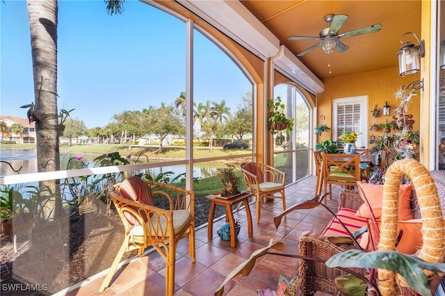 sunroom featuring a water view and ceiling fan