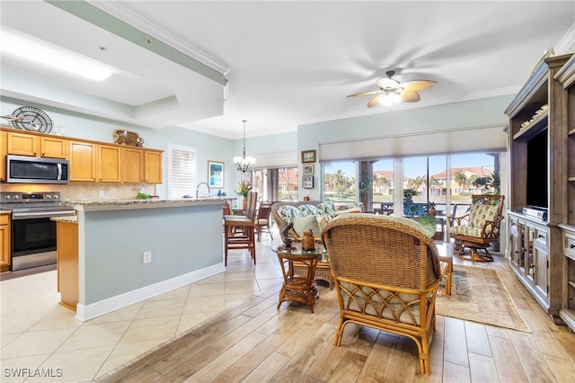 interior space featuring ceiling fan with notable chandelier, a wealth of natural light, ornamental molding, and light wood-type flooring